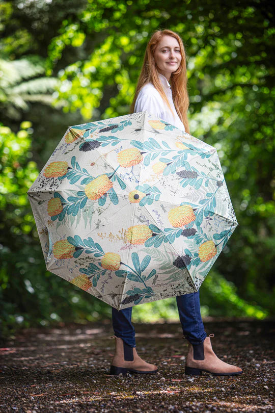 a woman is holding an umbrella in the woods