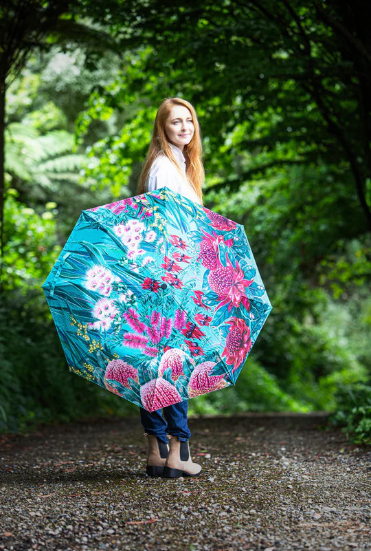 a woman holding an umbrella in a forest