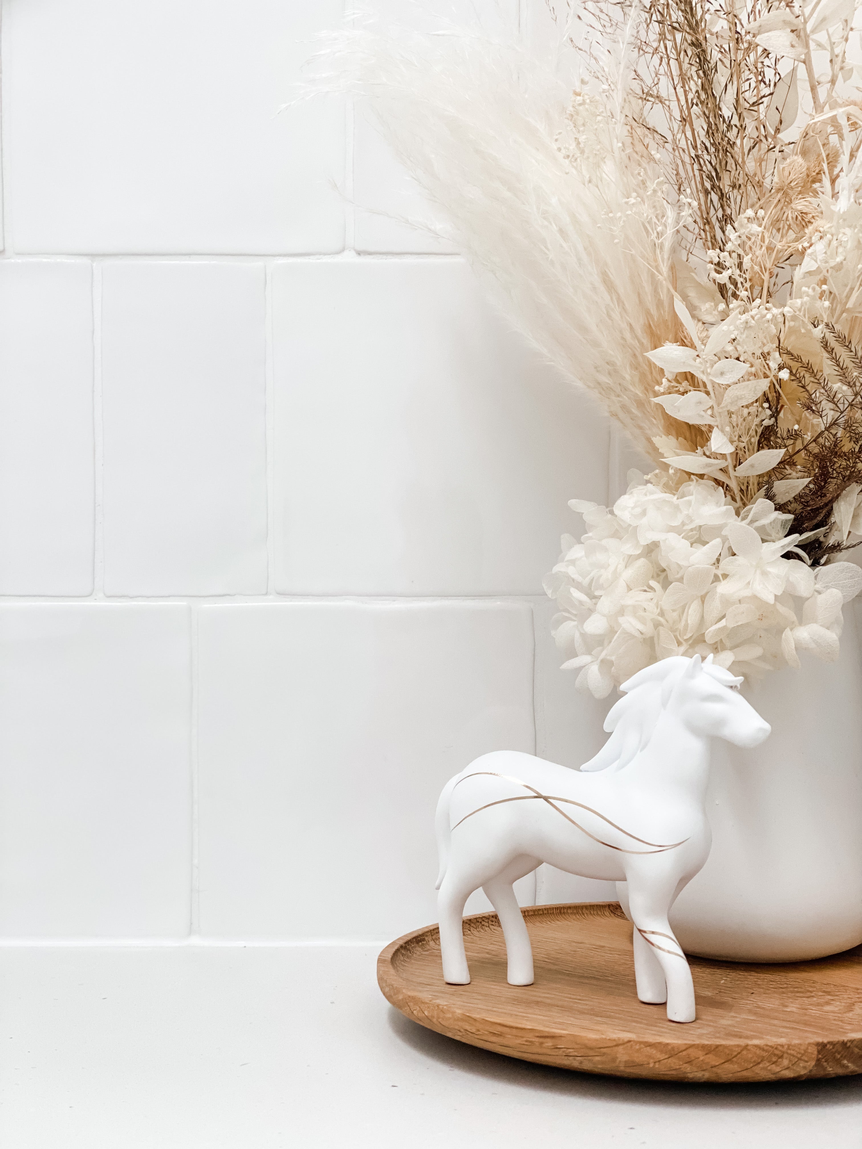 a white horse figurine sitting on a wooden tray
